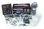 Traxxas Stampede 4x4 unassembled RC monster truck kit contents including box, transmitter, clear body shell, tires, and various bagged parts.