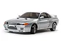 A silver Tamiya Nissan Skyline GT-R R32 RC drift car on a white background.