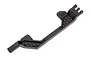 A black plastic Traxxas battery hold down bar with a honeycomb textured design, viewed from an angle against a white background.