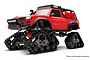 A red Traxxas TRX-4 RC truck equipped with black Traxx All-Terrain track kits instead of wheels, shown against a white background.