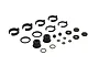 A collection of black composite RC shock parts including clips, spacers, O-rings, and pistons arranged on a white background.