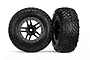 Two Traxxas 2.2/3.0 inch off-road tires pre-glued to black and satin chrome wheels, shown against a white background.