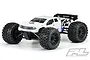 Pro-Line Brute Bash Armor white body shell installed on an RC truck with large knobby tires and a black rear wing against a white background.