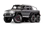 A studio shot of the Traxxas TRX-6 Mercedes-Benz G63 AMG 6x6 RC rock crawler in matte grey with illuminated LED headlights and roof lights.