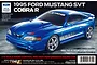A Tamiya 1/10 scale RC kit box featuring a blue 1995 Ford Mustang SVT Cobra R model car on a dark textured background.