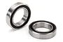Two Traxxas rubber-shielded ball bearings shown on a white background, one standing upright and one lying flat.