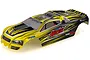A pre-painted yellow and black RC truck body shell with racing decals, viewed from a high angle against a white background.