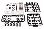 Axial 67-90mm aluminium shock absorber kit components laid out on a white surface, including metal shock bodies, springs, and plastic parts on sprues.