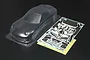 A clear, unpainted Tamiya 1/10 scale Mazda RX-7 RC car body shell with a decal sheet and white plastic parts tree on a black background.