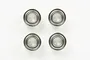 Four Tamiya metal shielded ball bearings arranged in a square pattern on a white background.