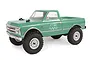 A green 1/24 scale Axial SCX24 1967 Chevrolet C10 RC rock crawler truck viewed from a front three-quarter angle against a white background.