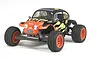 Tamiya Blitzer Beetle 1/10 scale RC truggy with a black and orange flame paint job, off-road tires, and orange wheels against a white background.