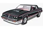 A completed 1/25 scale plastic model kit of a black 1983 Hurst Oldsmobile with red pinstriping and silver lower body panels.