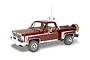 A 1/24 scale model of a 1976 Chevrolet Stepside pickup truck, painted deep red with white racing stripes, featuring a roll bar, off-road lights, and spare tire.