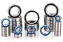 A collection of various sized metal ball bearings with blue and black rubber seals arranged in stacks on a white background.