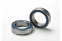 Two metal ball bearings with blue rubber seals resting on a white background.