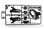 A black plastic Tamiya RC parts sprue containing suspension arms, gearbox components, and small mounts on a white background.