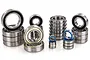 A collection of various sized metal ball bearings with rubber seals, arranged in stacks on a white background.