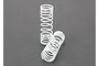 Two white progressive rate coil springs for RC car shock absorbers on a dark grey background.