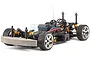 A studio shot of an HPI Sprint 2 Flux RC car chassis without the body shell, featuring orange shock absorbers and chrome wheels.