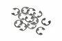 A pile of twelve small silver-coloured stainless steel E-clips for RC vehicles on a white background.
