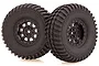 Two black RC off-road wheels with aggressive tread patterns and black 9-spoke rims, isolated on a white background.