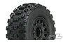 A close-up studio shot of a Pro-Line Badlands MX SC tyre mounted on a black Raid wheel for RC short course trucks.