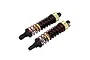 Two upgraded RC shock absorbers with black bodies, red springs, and gold adjustment collars, shown against a white background.