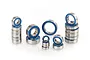 A collection of various sized metal ball bearings with blue rubber seals arranged on a white background.