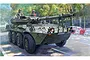 Box art illustration of a Spanish Army Centauro RCV armoured vehicle with a skull and crossbones emblem on the side, driving on a city street.