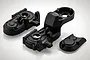 Black plastic RC gearbox case components for BlackZon 1/12 Warrior, including main housing and cover pieces.
