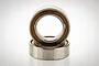 Two metal ball bearings stacked on a white background, showing silver outer rings and brown rubber seals.
