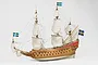 A detailed studio shot of a 1/65 scale wooden model of the Swedish Vasa warship, featuring white sails, rigging, and Swedish flags against a white background.