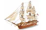 A fully assembled 1/85 scale wooden model of the 1797 US Navy Constellation frigate with white sails and rigging, displayed against a white background.