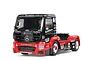 A Tamiya 1/14 scale RC Mercedes-Benz Actros MP4 racing truck model with black and red livery, featuring sponsor decals and a detailed cabin.