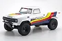Kyosho Outlaw Rampage 1/10 scale RC trophy truck in white with red, yellow, and blue racing decals on a white background.