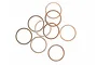 A collection of ten thin, circular copper washers scattered on a white background.