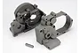 Traxxas grey gearbox halves and a metal idler gear shaft for RC vehicles.
