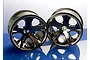Two Traxxas 2.8-inch All-Star rims with a black chrome finish, shown side-by-side on a reflective blue surface.
