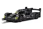 A 1/32 scale Scalextric Batman slot car featuring a dark, weathered grey and black aerodynamic racing design on a white background.