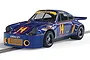 A 1/32 scale Scalextric slot car model of the blue 1974 Porsche 911 RSR 3.0 Trans Am, featuring number 14 and Kendall GT-1 branding on a track.