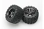 Two Traxxas 3.8 inch Talon monster truck tyres pre-glued onto black chrome Gemini rims against a white background.