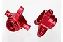 A pair of red anodized aluminium steering hubs for Traxxas RC vehicles, shown from different angles against a white background.