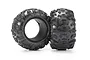 Two black rubber RC monster truck tyres with aggressive tread patterns and foam inserts, standing upright against a white background.