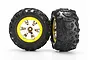 Two Traxxas 2.2 inch Canyon AT RC truck tires pre-glued onto yellow and chrome multi-spoke wheels against a white background.