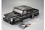 A black painted 1/10 scale RC crawler body shell by Killerbody, shown with included decal sheets and small plastic accessory parts on a grey background.