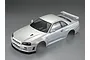 A pearl white painted 1/10 scale RC body shell of a Nissan Skyline R34, shown from a high-angle studio view.