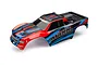 Traxxas Maxx 4S pre-painted body shell in red, blue, and black graphics with MAXX branding on the side.