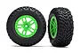 Two Traxxas 2.2/3.2 inch SCT off-road racing tyres mounted on bright green split-spoke wheels against a white background.