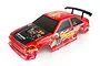 A red 1/10 scale RC car body shell with racing decals, carbon fiber hood pattern, and a black rear spoiler, isolated on a white background.